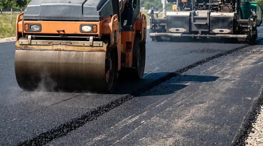 Asphalt on Asphalt 3 Heavy road roller compactor compacting asphalt on asphalt during driveway paving.
